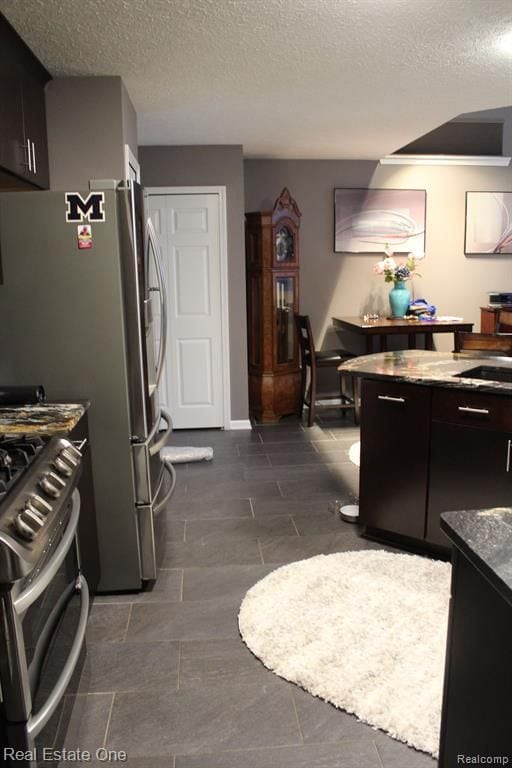 kitchen with a sink, stainless steel range with gas cooktop, and a textured ceiling
