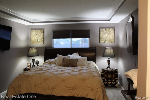 bedroom with crown molding, a tray ceiling, baseboards, and carpet