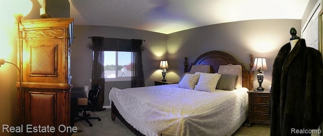 bedroom featuring vaulted ceiling and light carpet