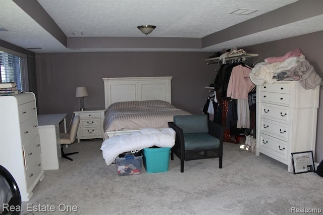 bedroom featuring a textured ceiling and light carpet