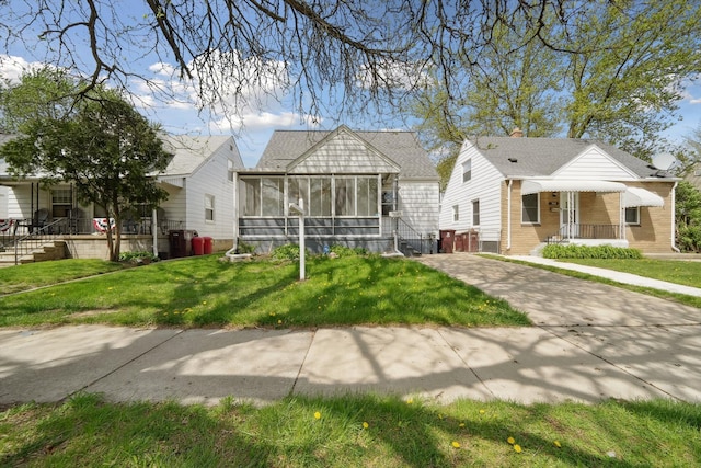 bungalow-style house featuring a sunroom and a front yard