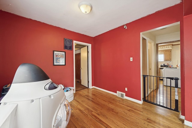 interior space with baseboards, light wood-style flooring, and visible vents