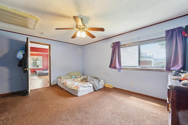 bedroom featuring crown molding, baseboards, carpet, and a textured ceiling