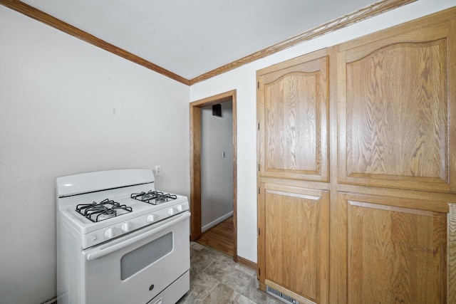 kitchen featuring visible vents, gas range gas stove, and ornamental molding
