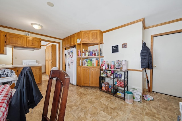 kitchen featuring light countertops, freestanding refrigerator, brown cabinetry, and ornamental molding