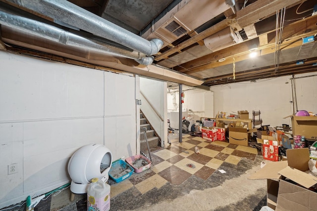 unfinished below grade area featuring visible vents, tile patterned floors, and stairway
