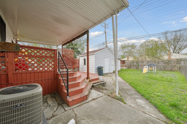 view of patio / terrace featuring central air condition unit, an outbuilding, and a fenced backyard