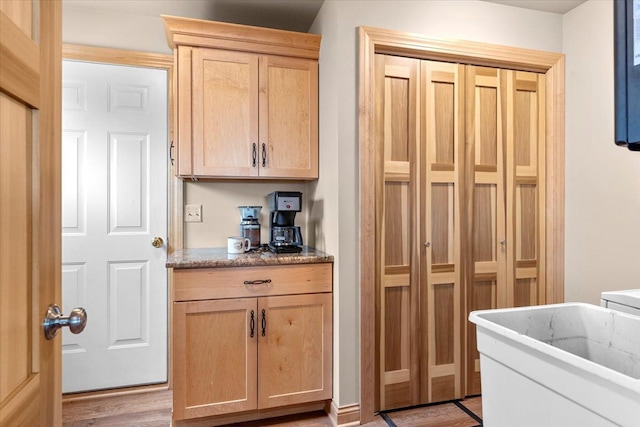 clothes washing area with light wood finished floors