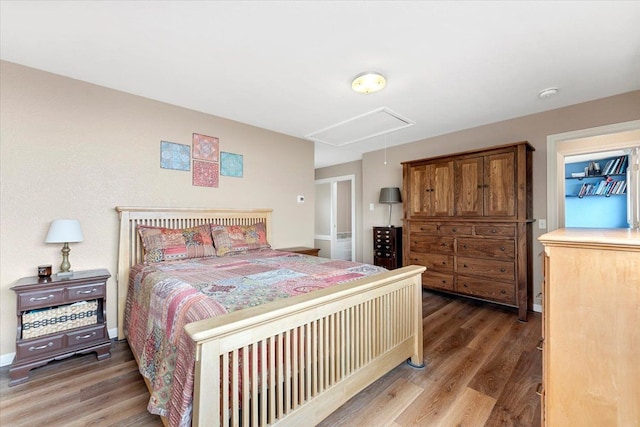 bedroom featuring attic access and wood finished floors