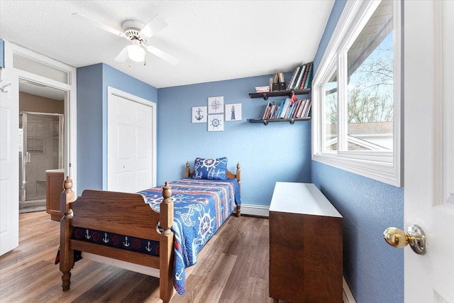 bedroom with a ceiling fan, baseboards, wood finished floors, and a baseboard radiator