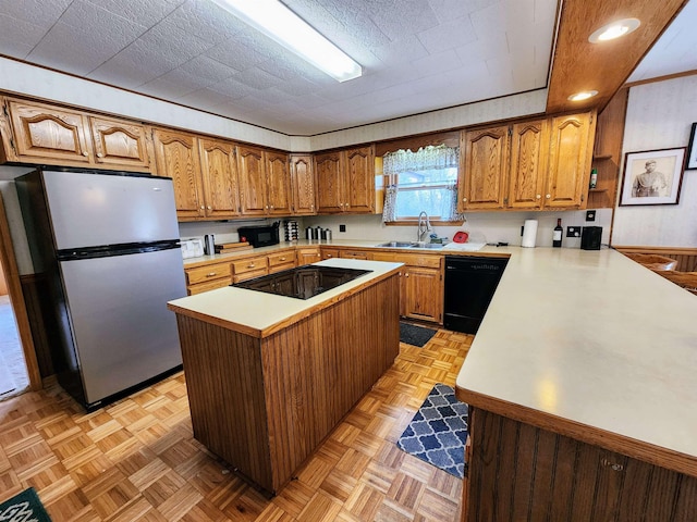 W11635 Lake St, Naubinway, MI 49762 - kitchen featuring brown cabinets, a sink, black appliances, and light countertops