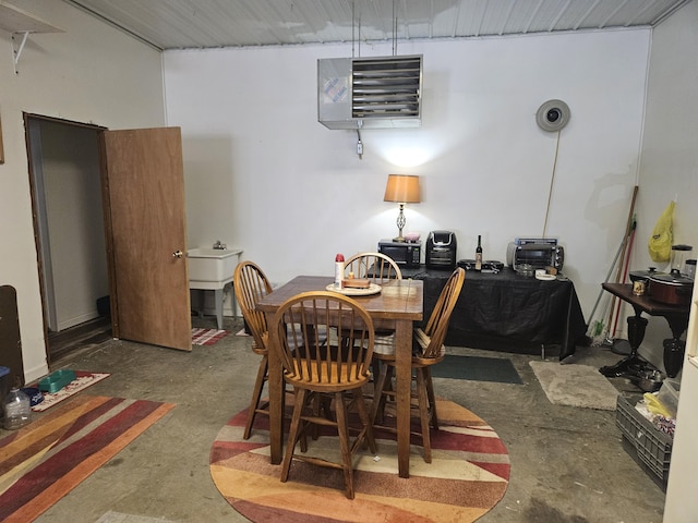 dining area featuring unfinished concrete floors and a heating unit
