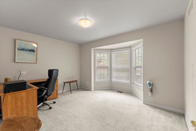 home office featuring light colored carpet, baseboards, and visible vents