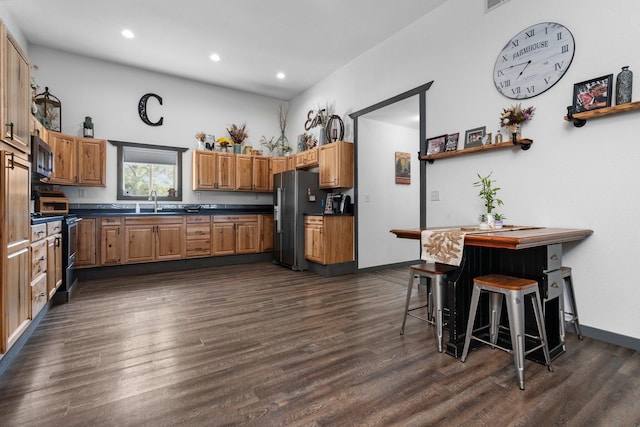 kitchen with dark wood finished floors, appliances with stainless steel finishes, and dark countertops