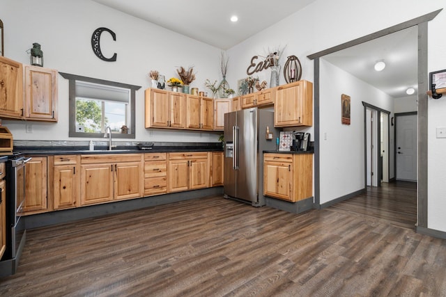 kitchen featuring a sink, dark wood finished floors, appliances with stainless steel finishes, and dark countertops