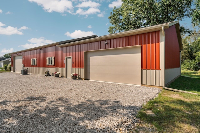 view of front of house with central air condition unit, an outbuilding, and a garage