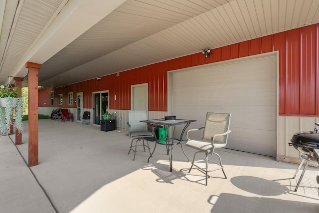 view of patio / terrace with a garage and outdoor dining space