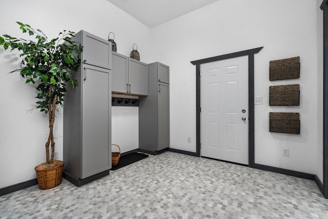laundry room with baseboards and light floors