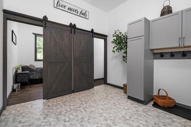 mudroom featuring baseboards and a barn door