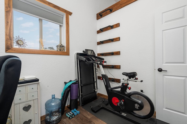 exercise area featuring baseboards and wood finished floors