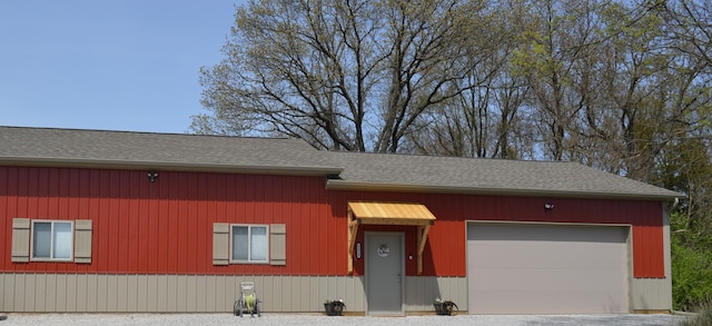 view of front of home with driveway, a shingled roof, and a garage