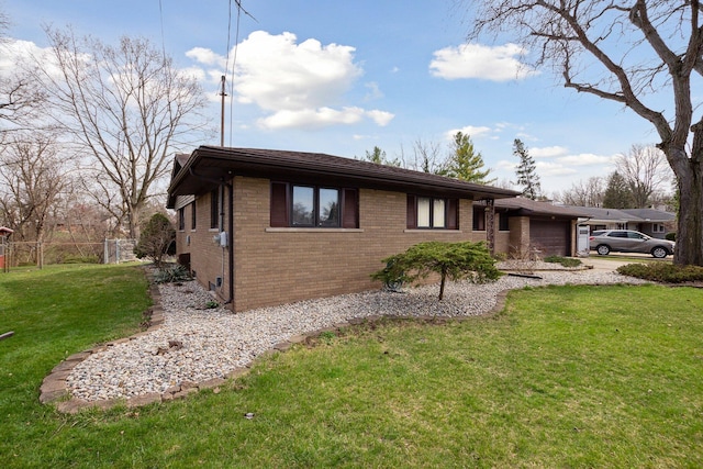 view of home's exterior featuring a garage, fence, a yard, and brick siding