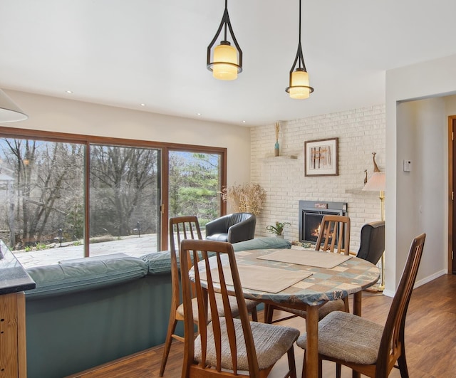 dining area featuring recessed lighting, wood finished floors, and a fireplace
