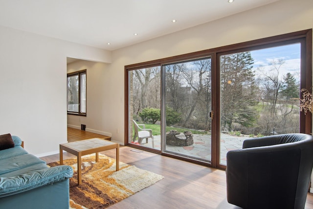 living area featuring baseboards, recessed lighting, wood finished floors, and visible vents