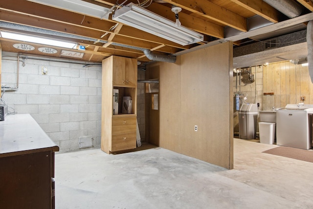 unfinished basement with concrete block wall and independent washer and dryer