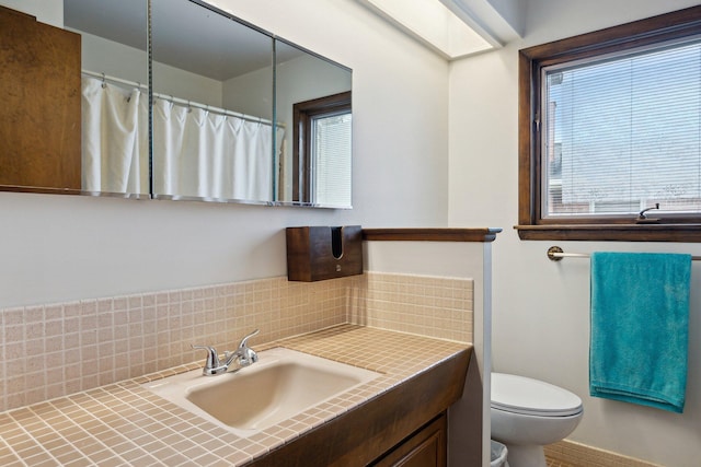 bathroom featuring backsplash, curtained shower, vanity, baseboards, and toilet