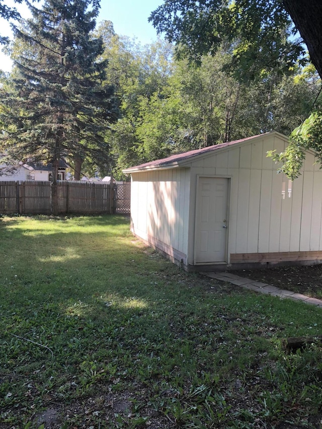 view of yard featuring fence and an outbuilding