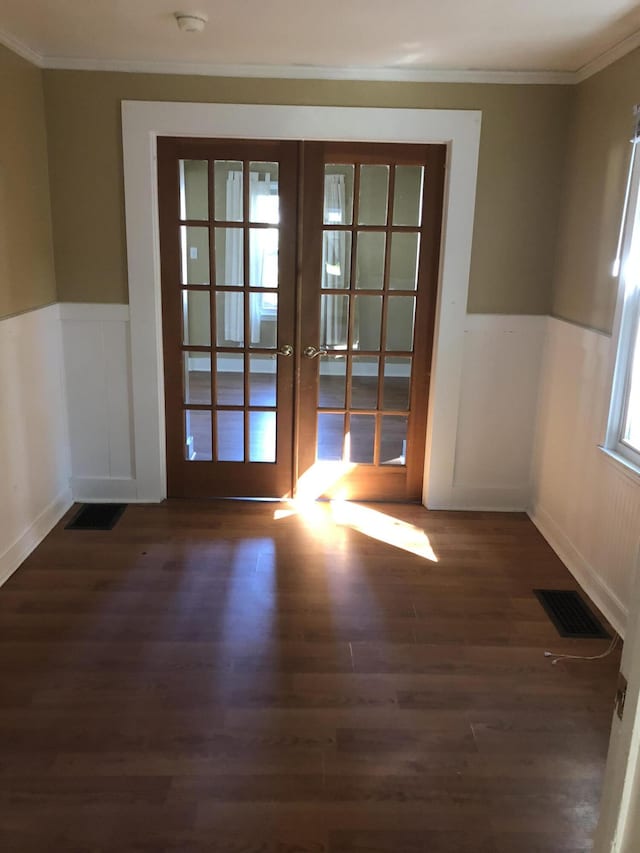 doorway with french doors, crown molding, wood finished floors, and visible vents