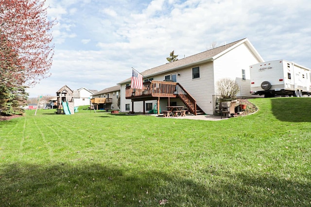 back of house with a lawn, a playground, stairway, and a deck