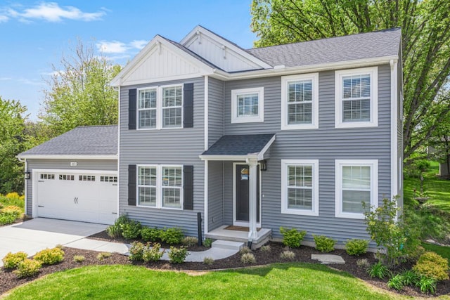 view of front of home featuring board and batten siding, driveway, a front yard, roof with shingles, and an attached garage