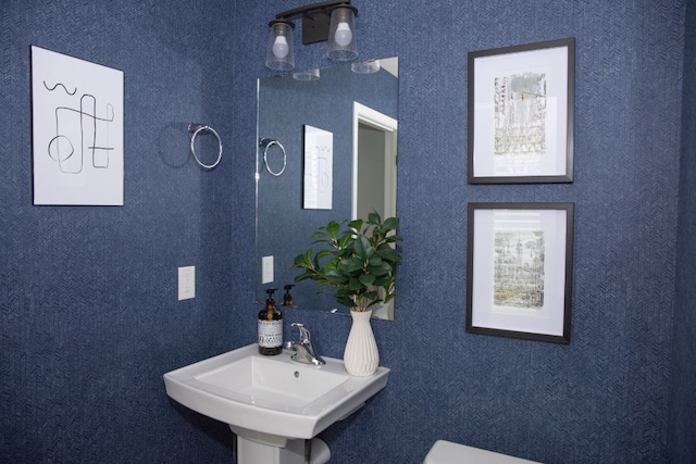 half bath with toilet, a wealth of natural light, and a sink