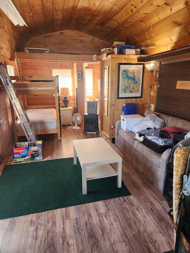 bedroom featuring wooden walls, wood ceiling, wood finished floors, and lofted ceiling