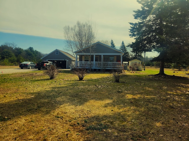 exterior space with a porch, an outbuilding, and a detached garage