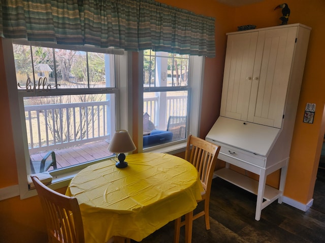 dining space with baseboards, a wealth of natural light, and wood finished floors
