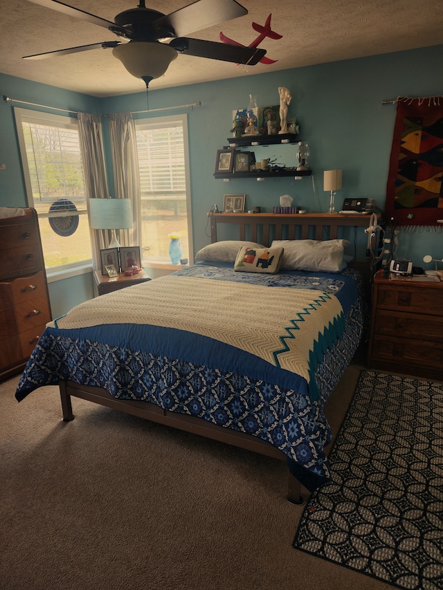 carpeted bedroom with a textured ceiling and ceiling fan