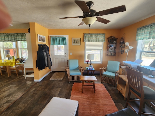 living area with baseboards, ceiling fan, and wood finished floors