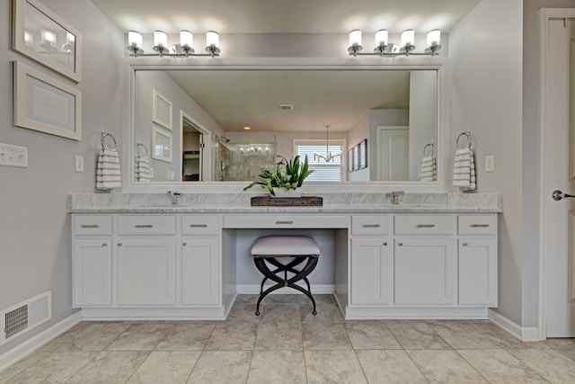 full bath with visible vents, double vanity, baseboards, a sink, and a stall shower