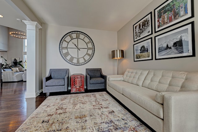 living room featuring decorative columns, baseboards, recessed lighting, dark wood finished floors, and a notable chandelier