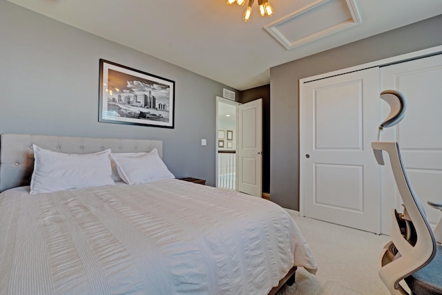 carpeted bedroom with visible vents, attic access, and a closet