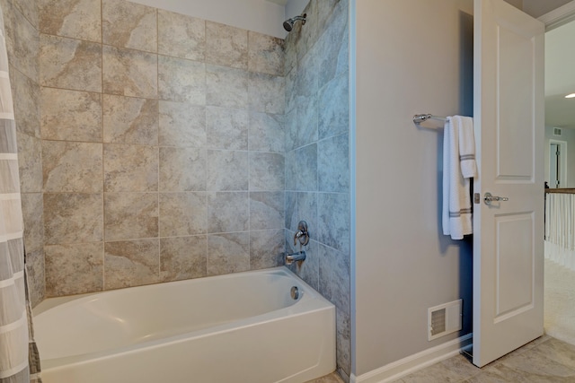 bathroom featuring baseboards, visible vents, and shower / tub combination
