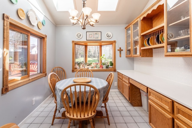 dining space with light tile patterned floors, crown molding, plenty of natural light, and a chandelier