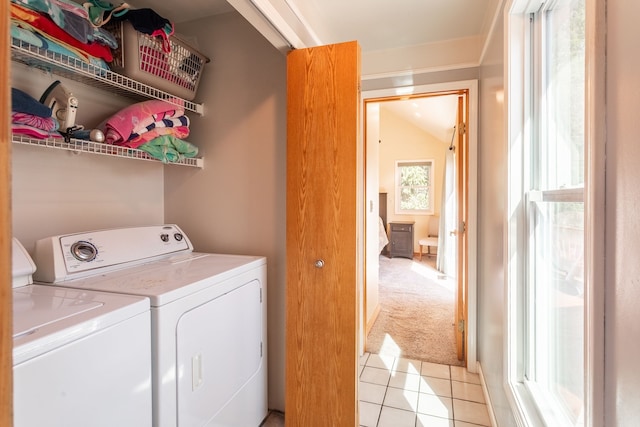 washroom with washing machine and clothes dryer, light tile patterned flooring, and laundry area