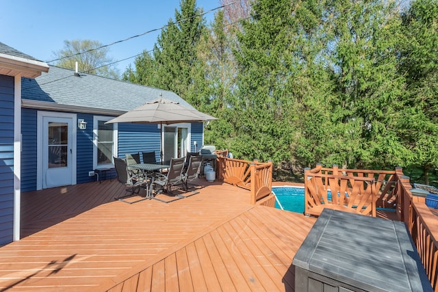 deck featuring outdoor dining area and an outdoor pool