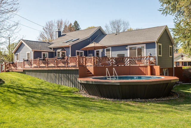 rear view of property featuring a lawn, a wooden deck, and a shingled roof