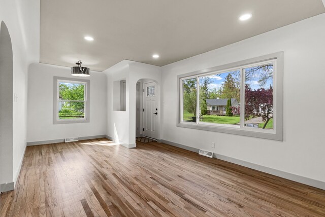 5857 Berkley Dr, Waterford, MI 48327 - unfurnished living room featuring arched walkways, wood finished floors, baseboards, and recessed lighting