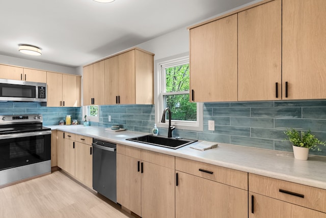 5857 Berkley Dr, Waterford, MI 48327 - kitchen with appliances with stainless steel finishes, light brown cabinets, a sink, light countertops, and backsplash